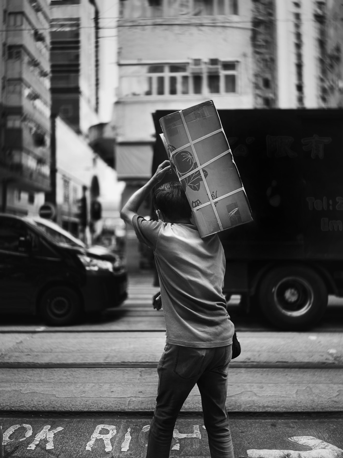 A Brother Movers crew member carrying a large, carefully packed box